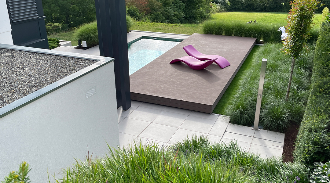 Ein moderner Hinterhof mit einem Pool und einem lila Liegestuhl.